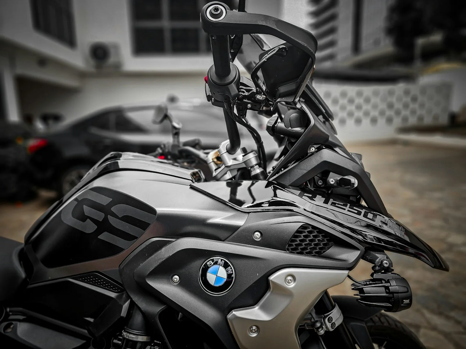 BMW R1250GS geparkeerd voor een gebouw in Accra, Ghana, foto door Claude Nai op Unsplash