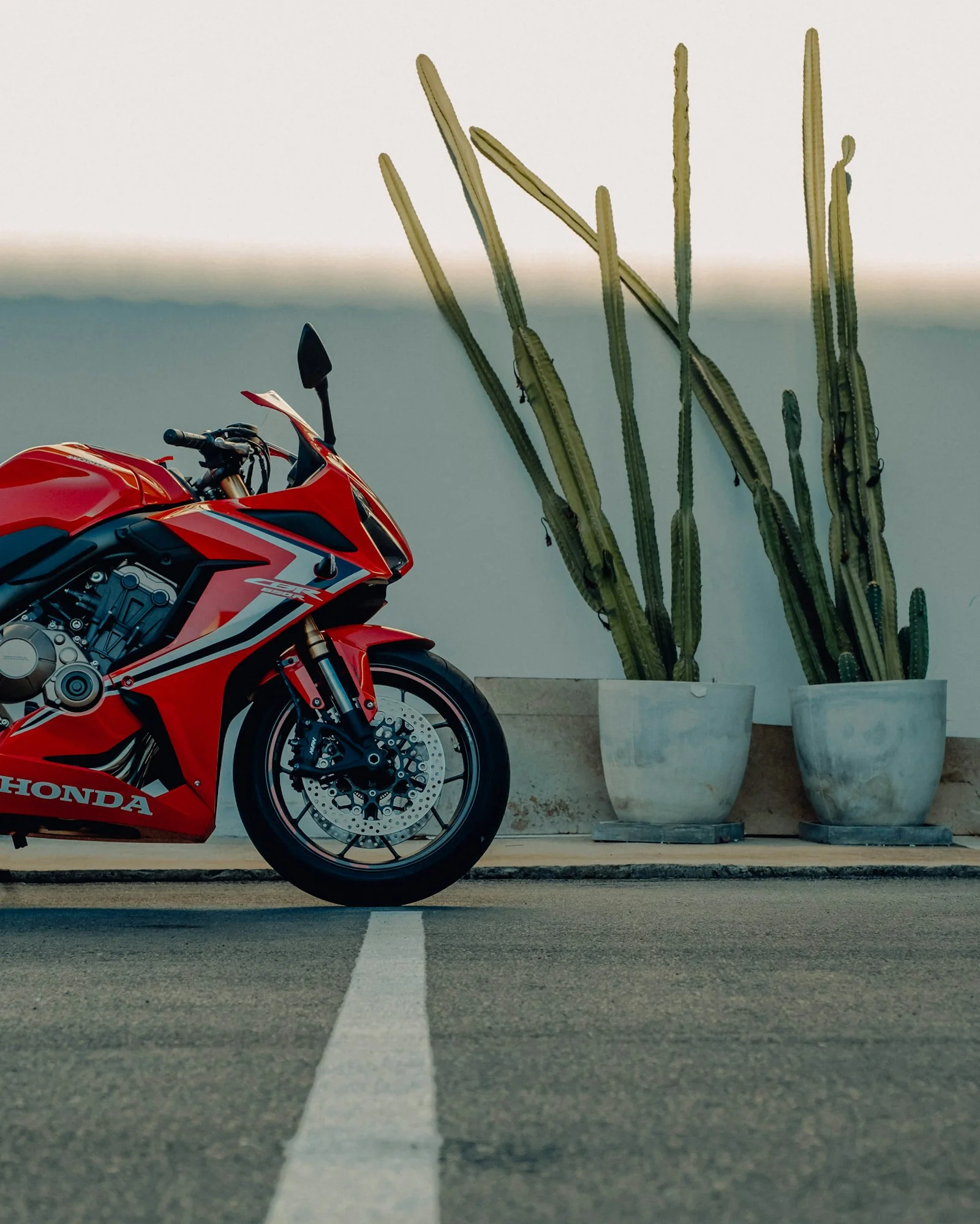 Rode en zwarte Honda sportmotor geparkeerd, foto door Christophe Meyer op Unsplash