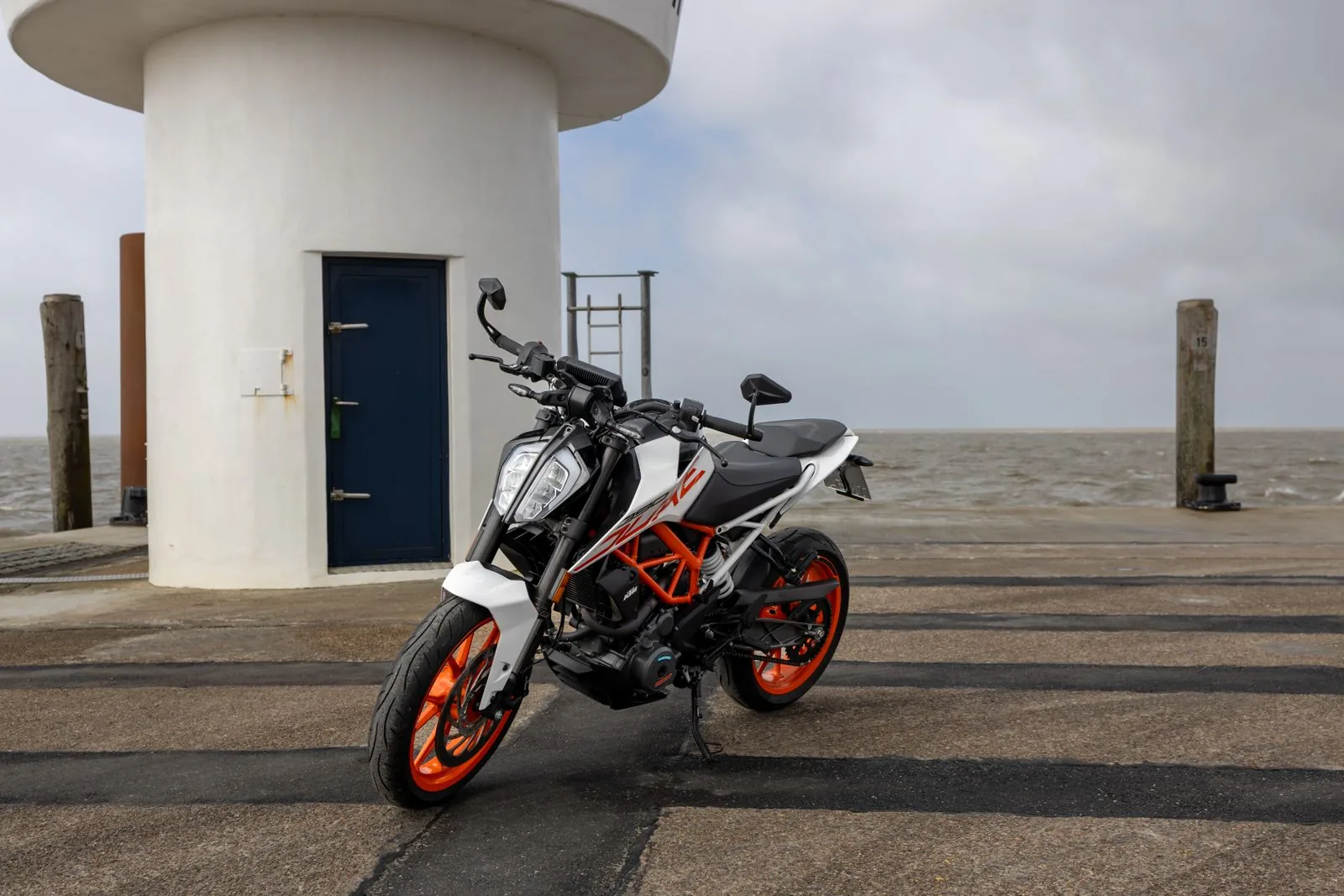 KTM Duke 390 geparkeerd bij een vuurtoren in Dagebüll, Duitsland, foto door Joerg Mangelsen op Pexels